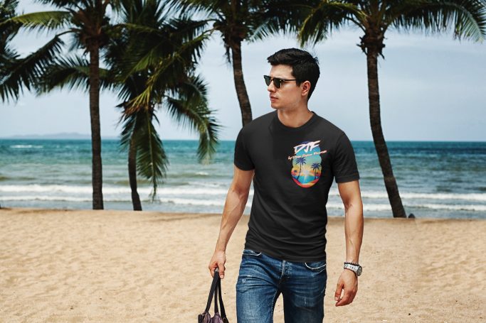 Mann in schwarzem DJF by Dean Jayson Freeman T-Shirt und Sonnenbrille läuft am Strand, Palmen im Hintergrund.