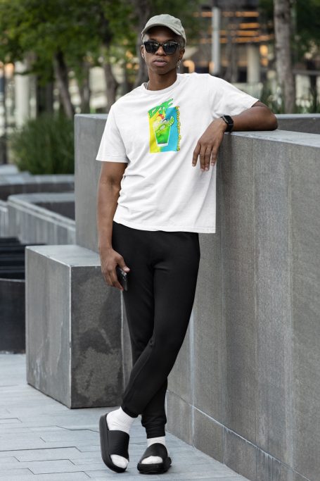Junger Mann in weißem DJF by Dean Jayson Freeman T-Shirt und schwarzer Hose, steht entspannt an einer Mauer.