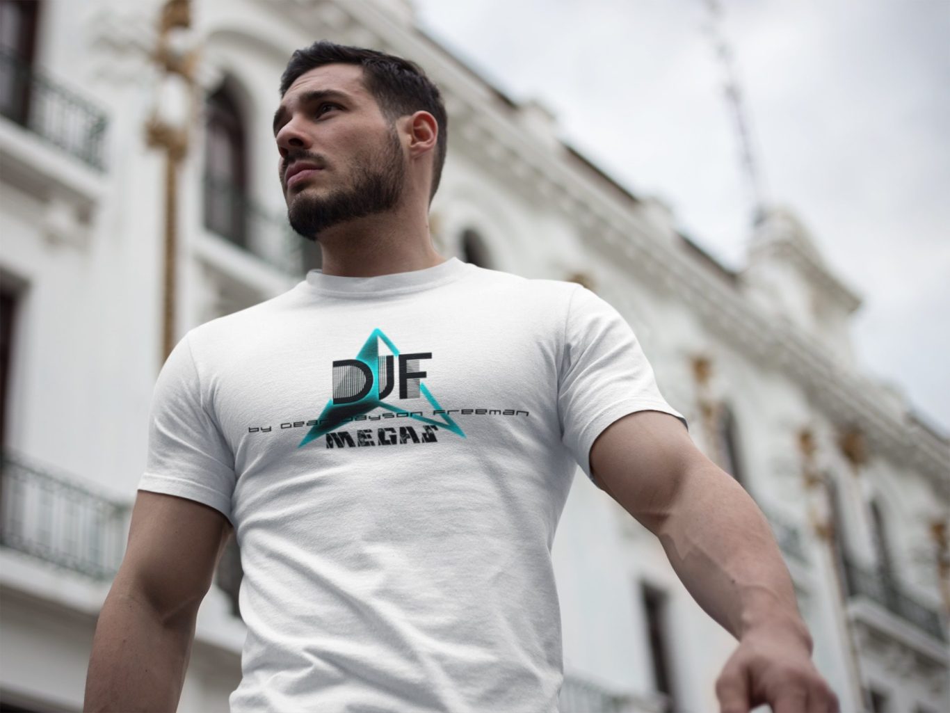 Mann in weißem DJF by Dean Jayson Freeman T-Shirt mit Grafikprint, posiert vor einer klassischen Fassade.