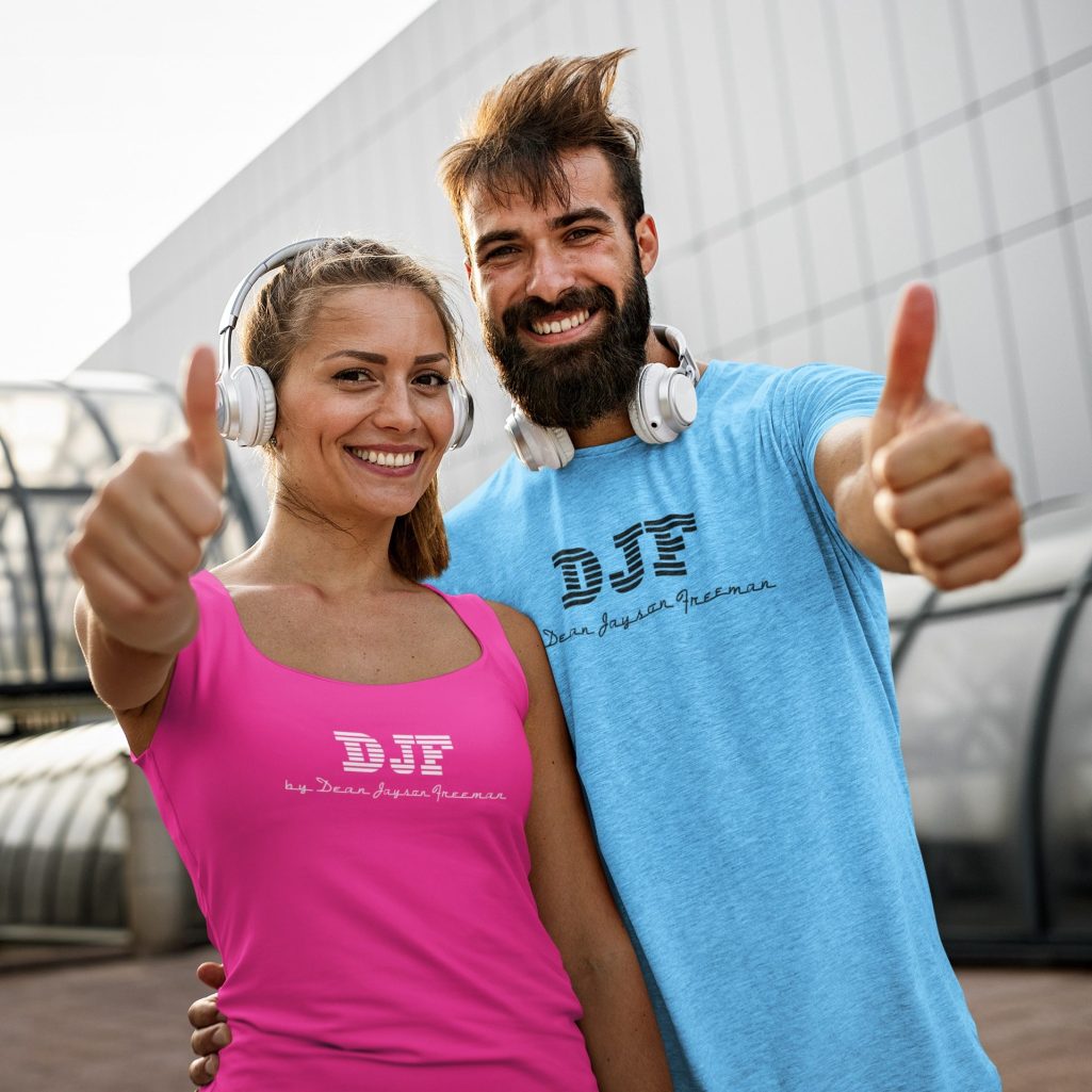 Lächelndes Paar in DJF by Dean Jayson Freeman Sportkleidung mit Kopfhörern, Daumen hoch.