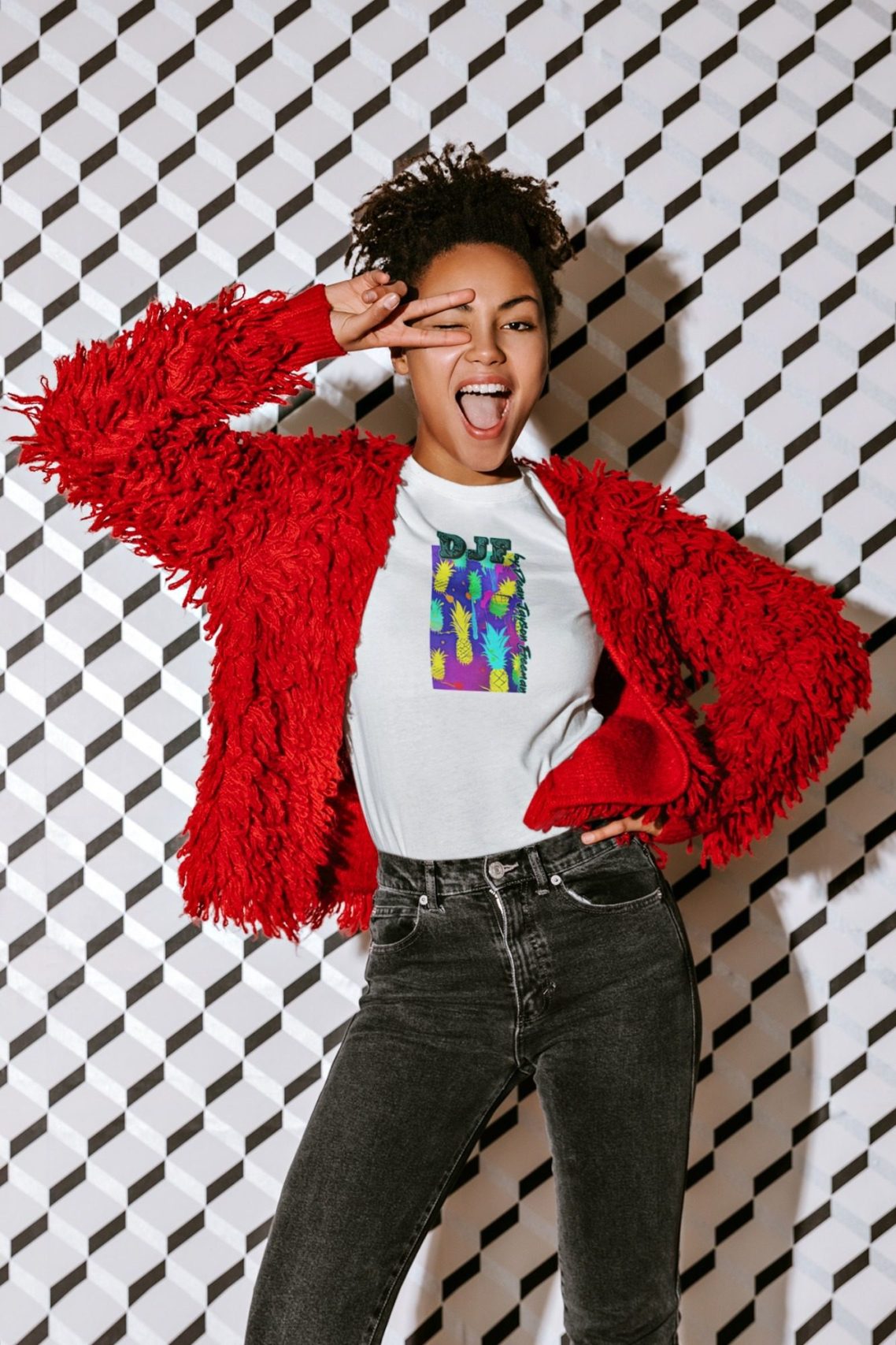 Junge Frau in rotem, flauschigem Cardigan posiert mit einem weißen DJF by Dean Jayson Freeman T-Shirt mit fröhlichen Ausdruck.