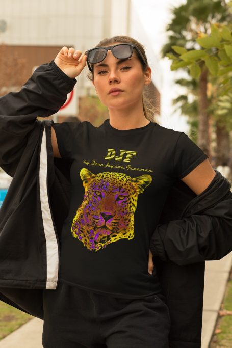 Junge Frau trägt ein schwarzes DJF by Dean Jayson Freeman T-Shirt mit farbenfrohem Löwenkopf-Design.